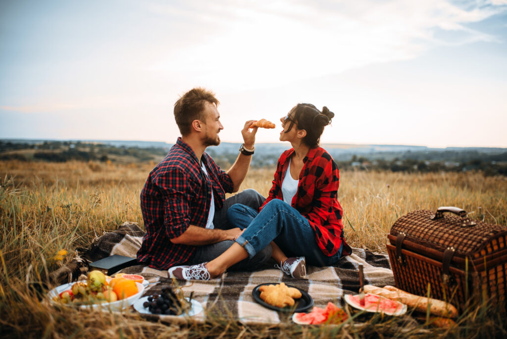 A young couple having a picnic in a field.