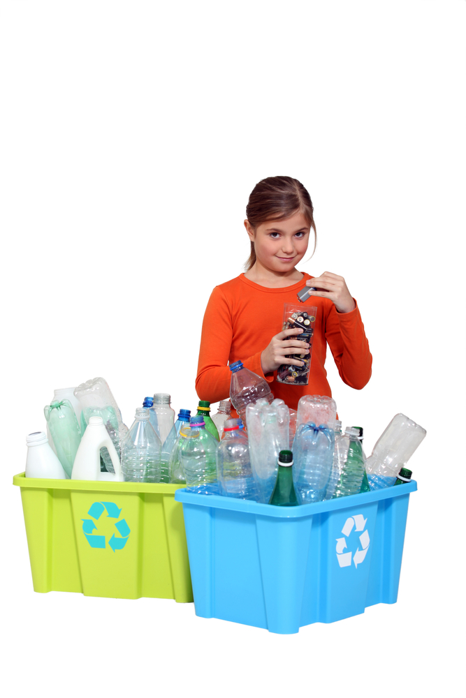 Young girl recycling single used plastic bottles and batteries.